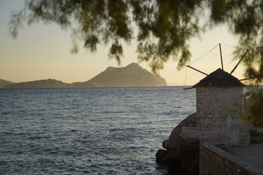 A windmill with the sea and the sunset