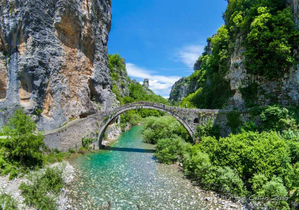 A stone bridge over a river connecting a gorge