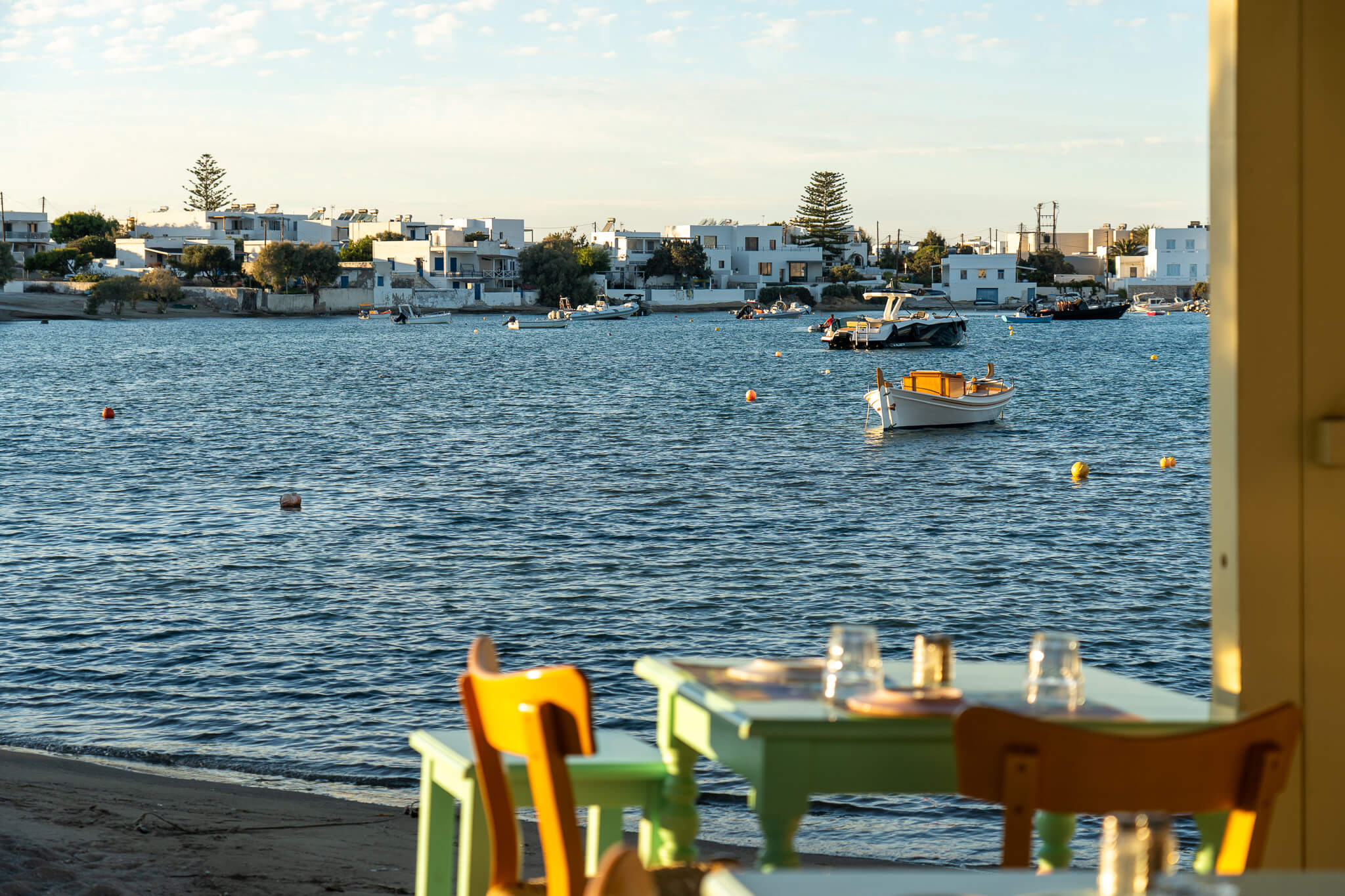 A restaurant table in front of the sea during sunset